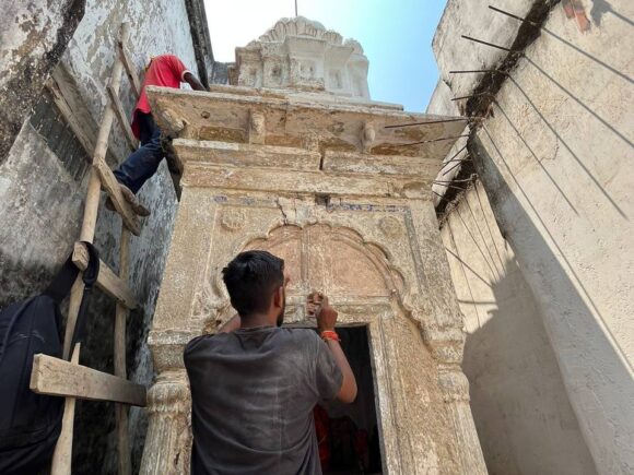 Worker carefully repairing the doorway and stone carvings of the ancient Ganesha temple in Bhandara during restoration by Ramdoot Restores.