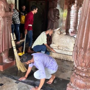 Ramdoot Restores volunteers cleaning temple floor and sacred Nandi statue during restoration seva.