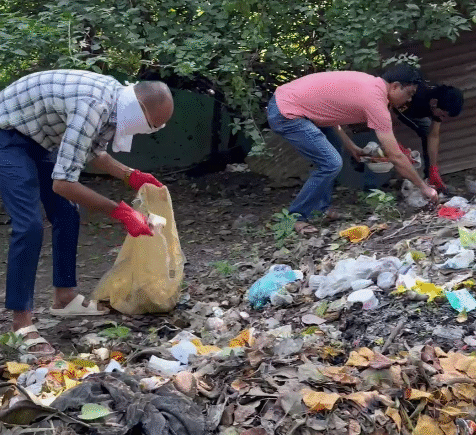 Ramdoot Restores volunteers cleaning garbage near a temple site.